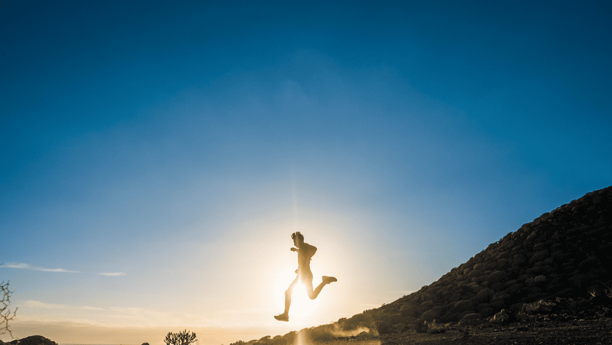 Zdjęcie przedstawia mężczyznę biegającego na tle malowniczego zachodu słońca nad górami. Aktywność fizyczna to ważny element dbania o zdrowie serca.